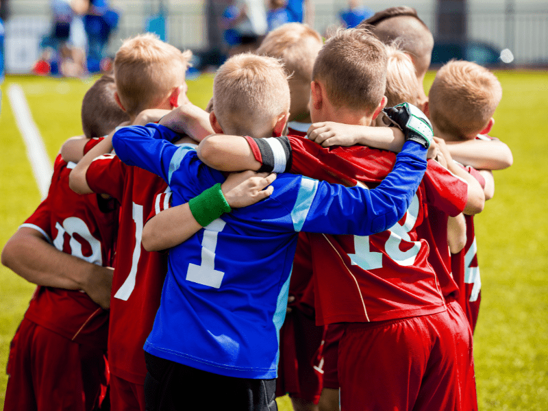 Group of homeschool children playing soccer together outdoors
