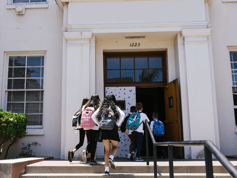 Child with a backpack entering a Florida public school, resuming an IEP