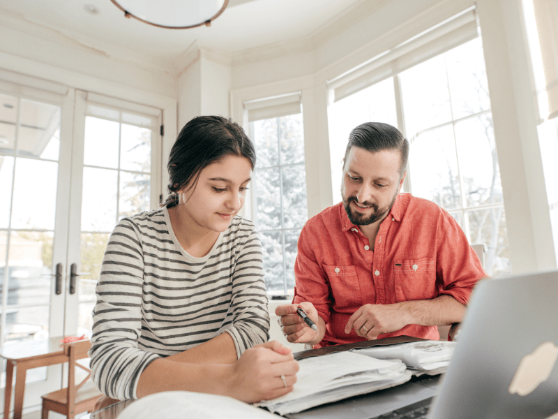 Parent and teen reviewing online homeschool class options on a laptop.”Title: “Enroll in Online Homeschool Classes